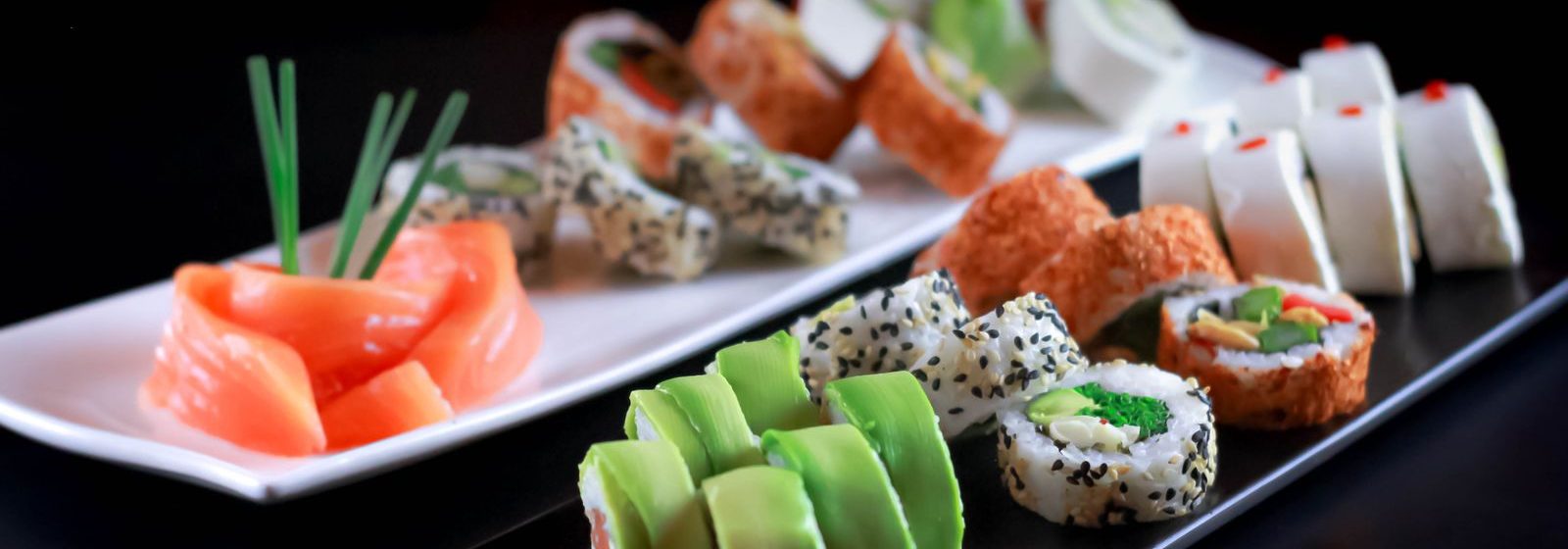 Sushi-Platte mit Lachs-Sashimi, Maki und Avocado-Rollen